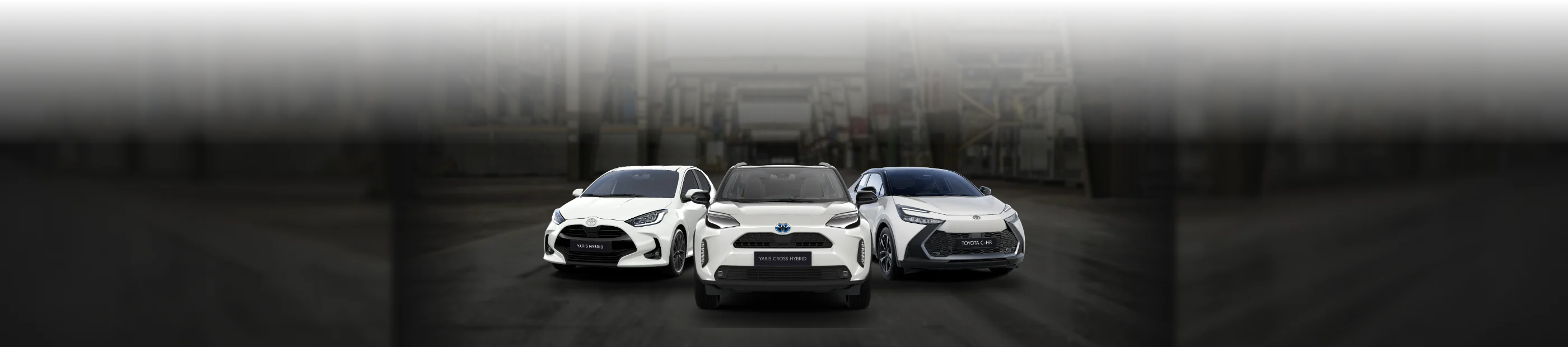 Toyota Yaris Hybrid, Toyota Yaris Cross Hybrid und Toyota C-HR Hybrid in Weiß in einer Halle